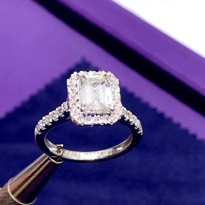18kt White Gold Engagement Ring with 1.8 carat lab diamond at the center (Color: E | Clarity: VS1 | Emerald Cut) and E / VVS grade natural diamonds in cathedral / halo setting.